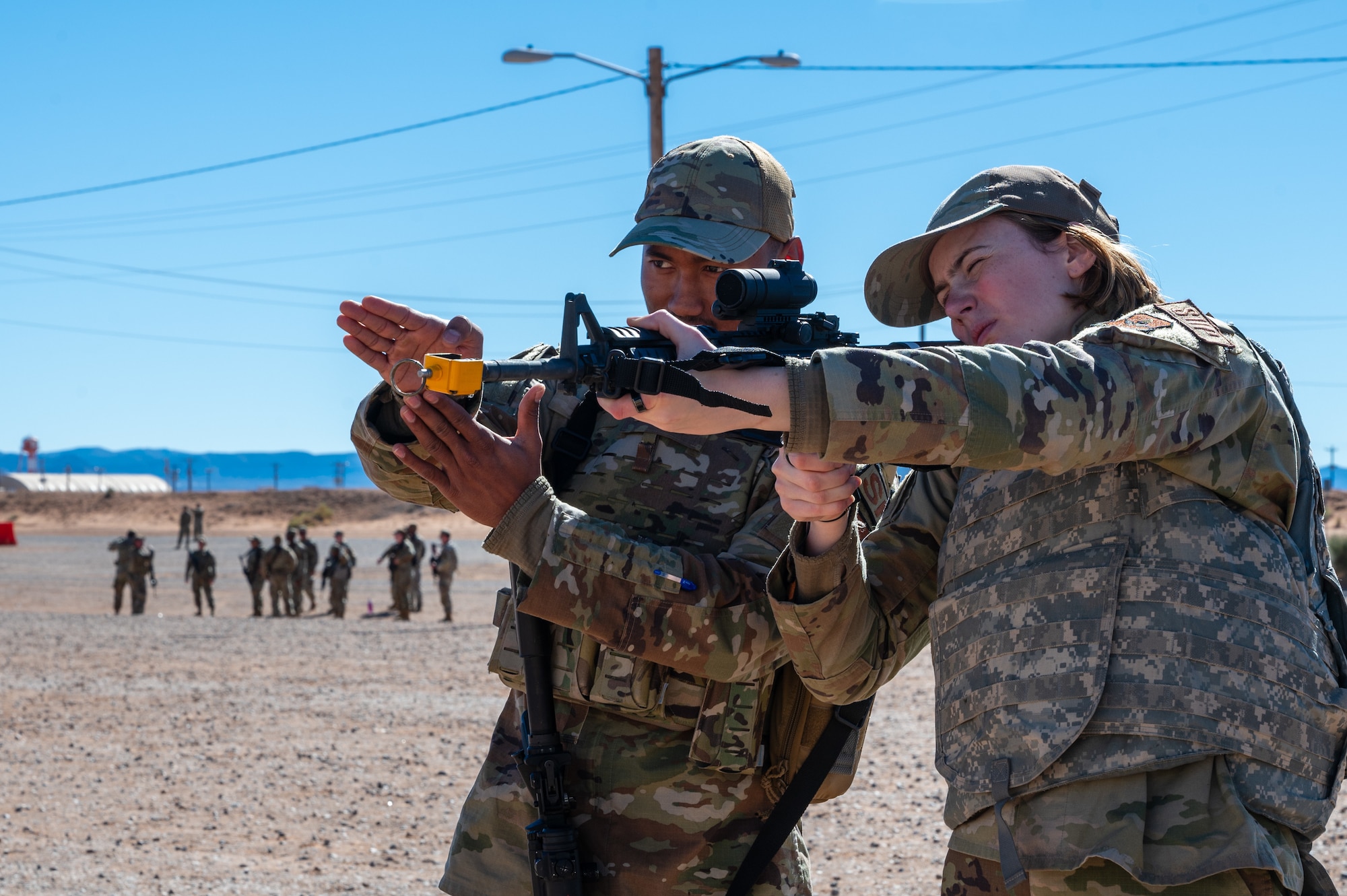 U.S. Air Force Airman 1st Class Shyam Khadka, 49th Security Forces Squadron specialist, instructs Airman 1st Class Madeline Johnson, 49th Logistics Readiness Squadron customer service representative, during the 11th Air Task Force’s first field exercise at McGregor Range, New Mexico, Nov. 10, 2024. Security forces Airmen conducted weapons familiarization and tactical movement training for fellow 11th ATF members. (U.S. Air Force photo by Airman 1st Class Jasmyne Bridgers-Matos)