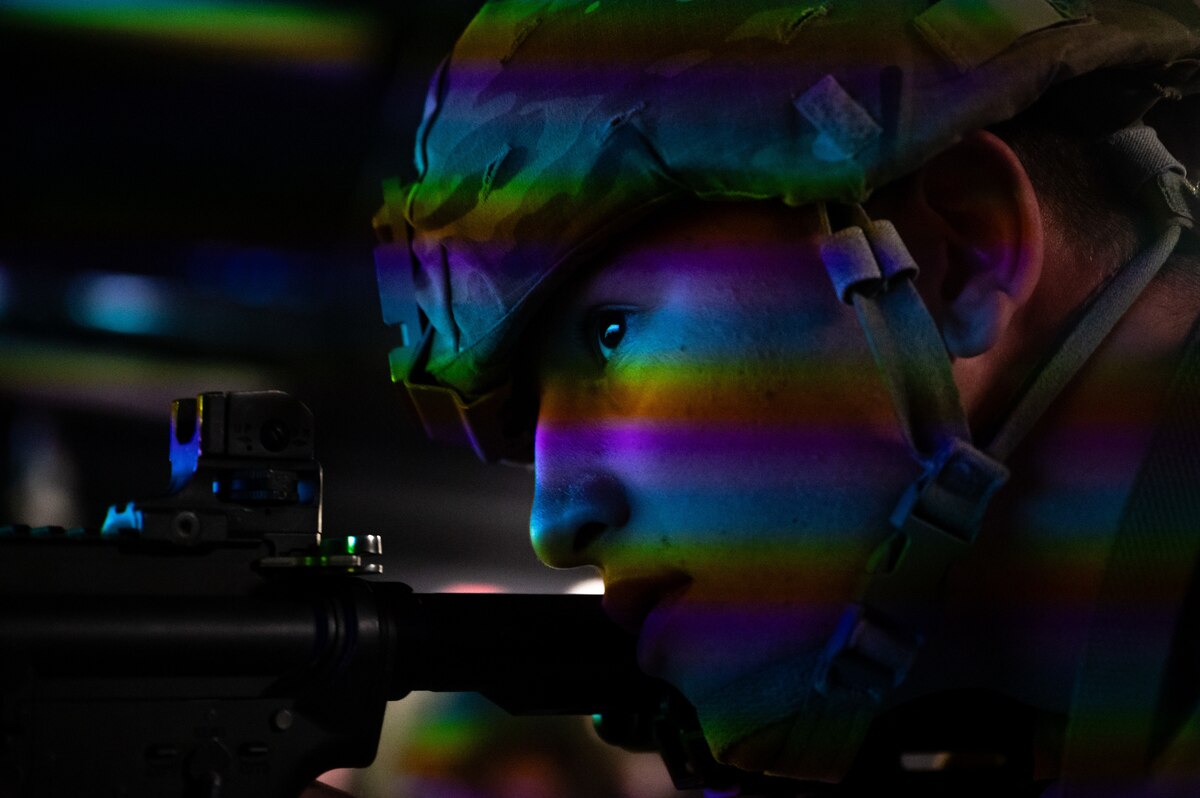 A U.S. Airman assigned to the 11th Air Task Force aims an M4 carbine at the Gunfighter Gymnasium during the 11th ATF’s first field exercise at McGregor Range, New Mexico, Nov. 12, 2024. The Gunfighter Gym is a laser-based simulator at Fort Bliss, Texas, that helps service members improve their shooting skills. (U.S. Air Force photo by Airman 1st Class Jasmyne Bridgers-Matos)