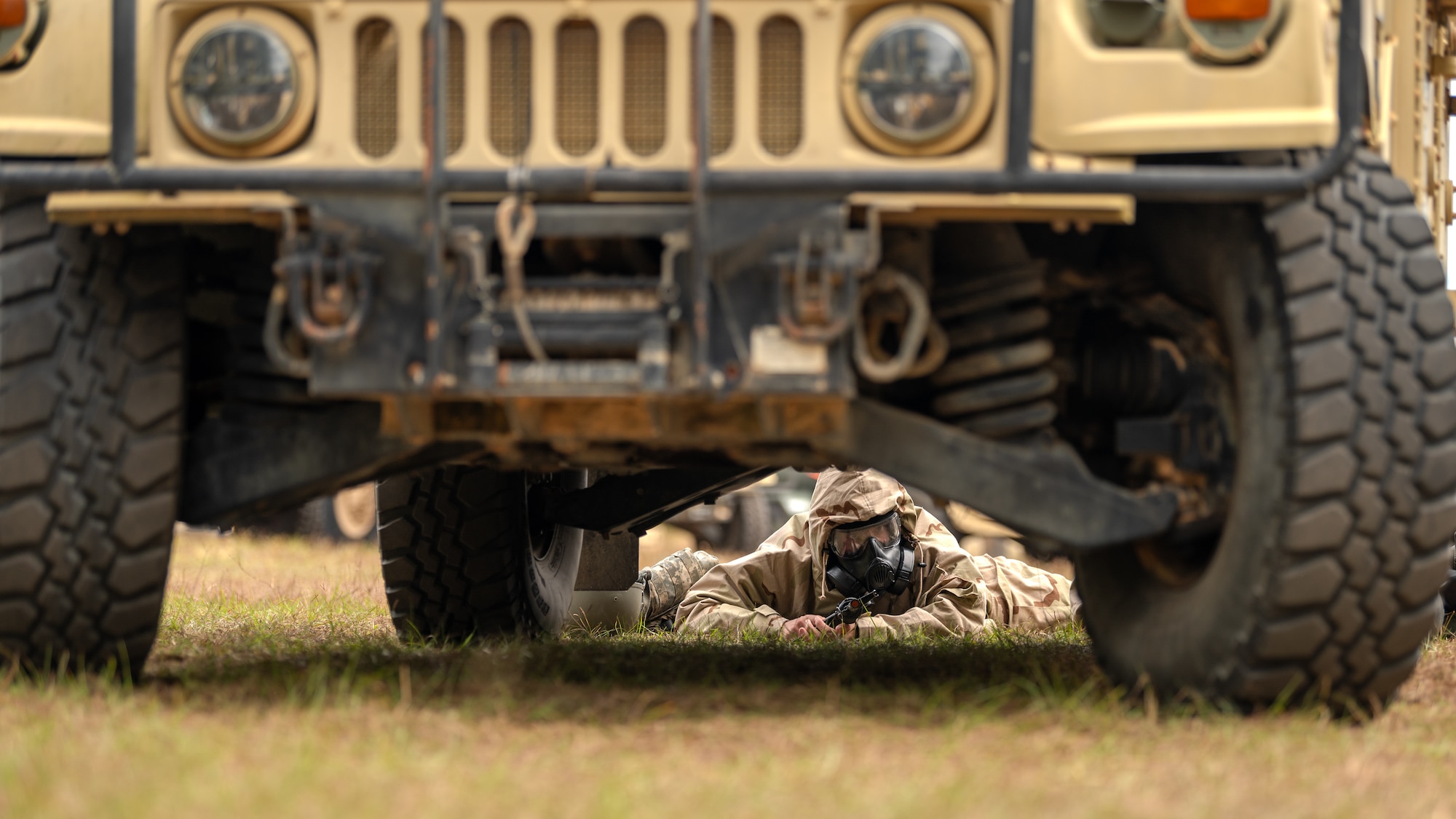 A U.S. Airman, assigned to the 1st Special Operations Mission Support Group, takes cover behind a humvee during a bivouac exercise at Eglin Range, Eglin Air Force Base, Florida, Nov. 5, 2024.