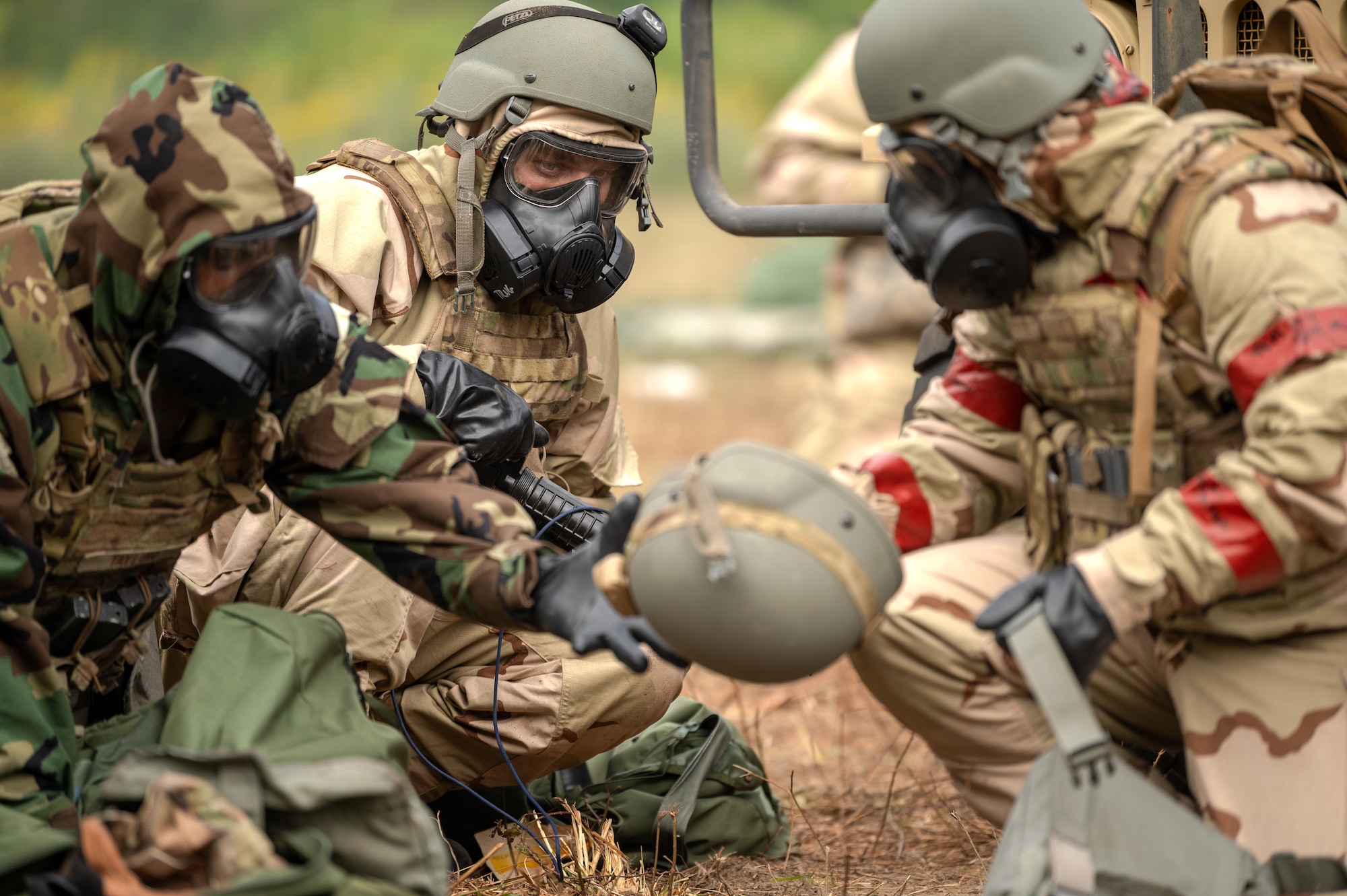 U.S. Airmen assigned to the 1st Special Operations Mission Support Group, take cover behind a humvee after donning Chemical, Biological, Radiological and Nuclear gear during a bivouac exercise at Eglin Range, Eglin Air Force Base, Florida, Nov. 5, 2024.