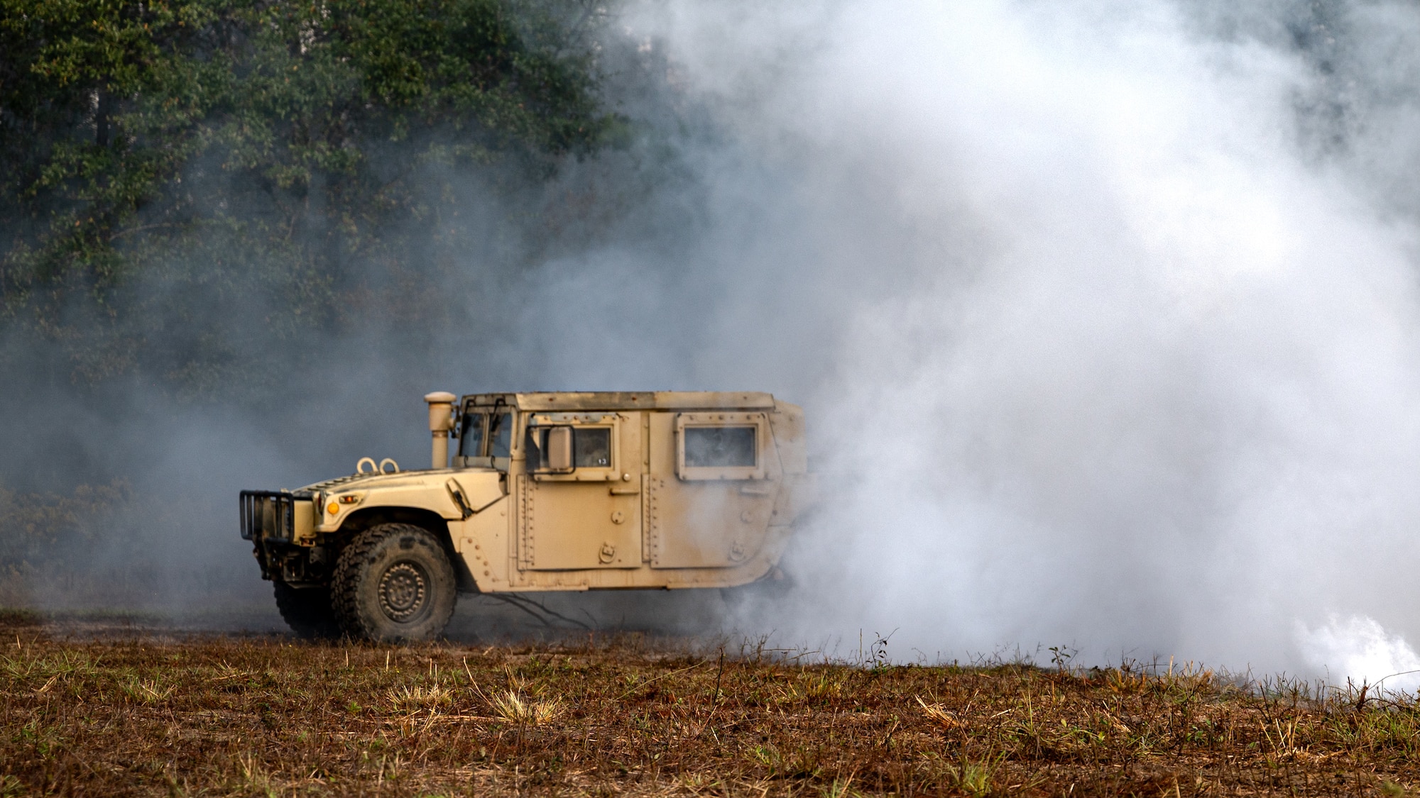 A U.S. Air Force Airman drives a humvee through smoke during a bivouac exercise at Eglin Range, Eglin Air Force Base, Florida, Nov. 5, 2024.