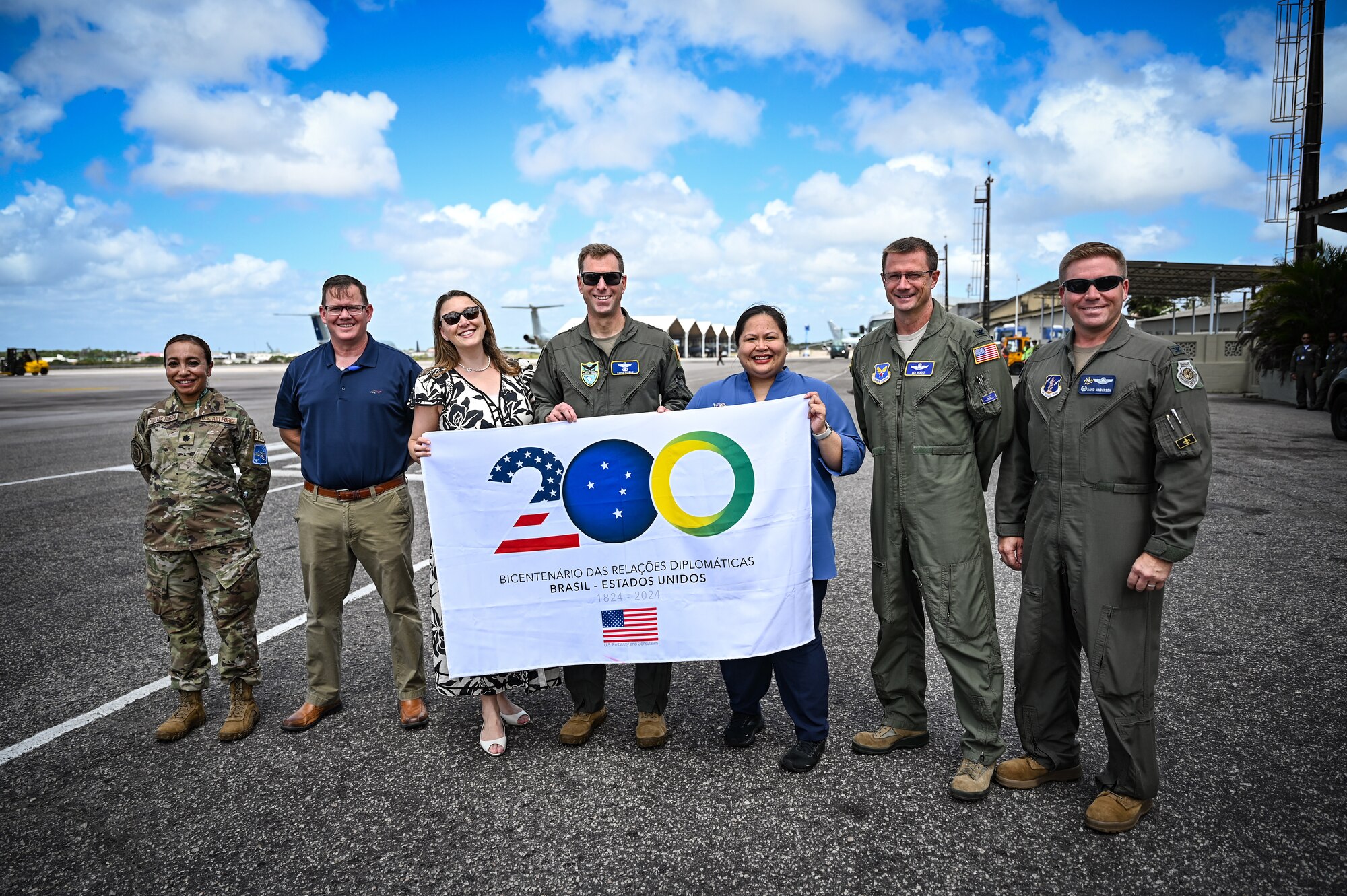 United States distinguished visitors and diplomats hold a sign celebrating the bicentennial diplomatic relationship between the U.S. and Brazil during CRUZEX 2024 at Natal Air Force Base, Brazil, Nov. 9, 2024. Since 1824 the U.S. and Brazil have shared values, aspirations, and a commitment to democracy that have shaped the partnership and driven prosperity in the Western Hemisphere. (U.S. Air Force photo by Staff Sgt. Madeline Herzog)