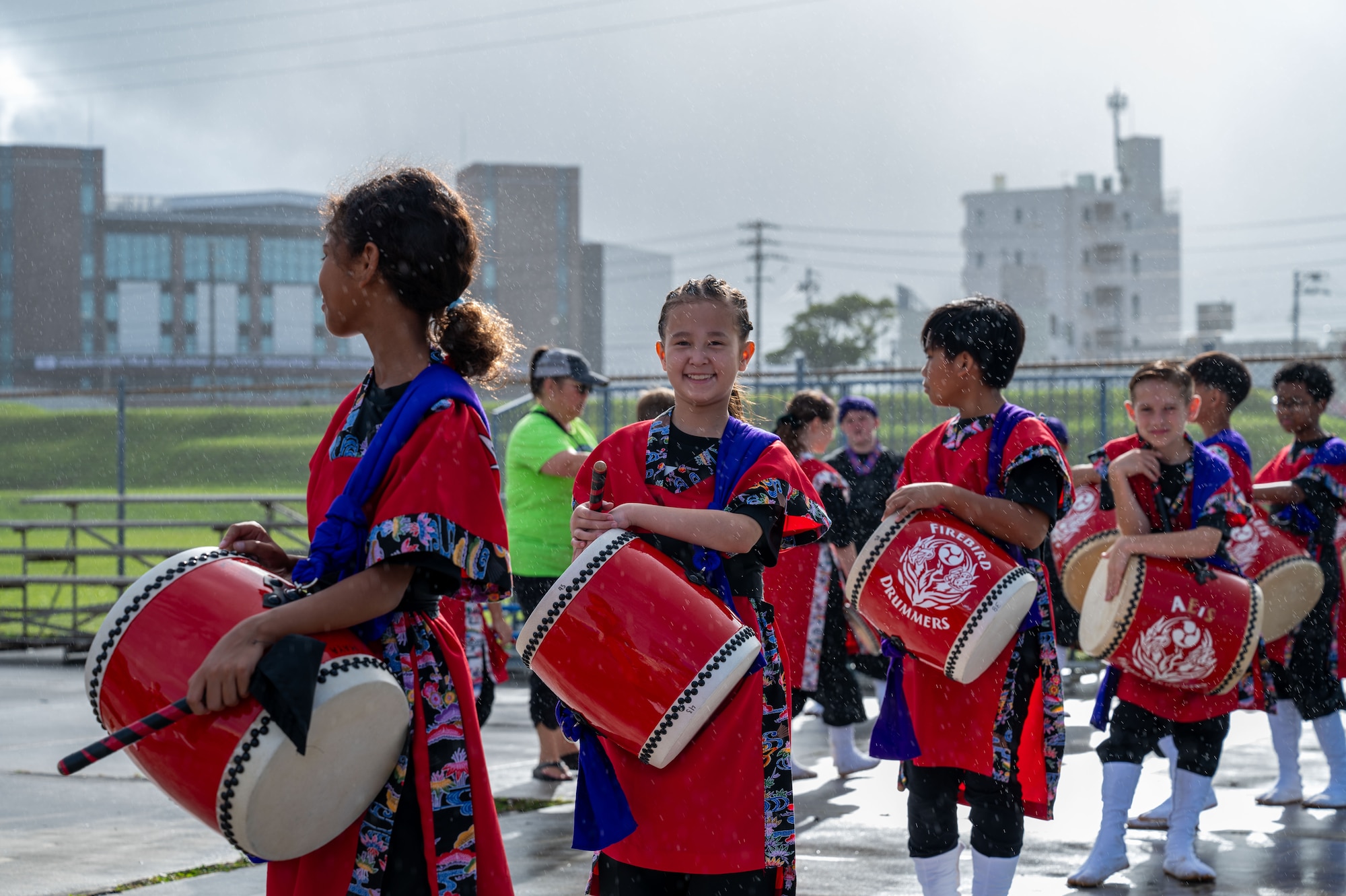 A female drummer smiles a the camera