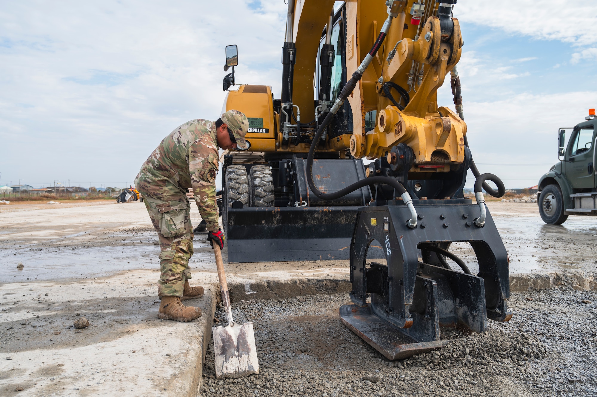 U.S. Air Force Staff Sgt. Steven Morales, 8th Civil Engineer Squadron pavements and construction equipment operator, spreads concrete for an expedient and expeditionary airfield damage repair on the flightline during Beverly Sentinel 25-1 at Kunsan Air Base, Republic of Korea.