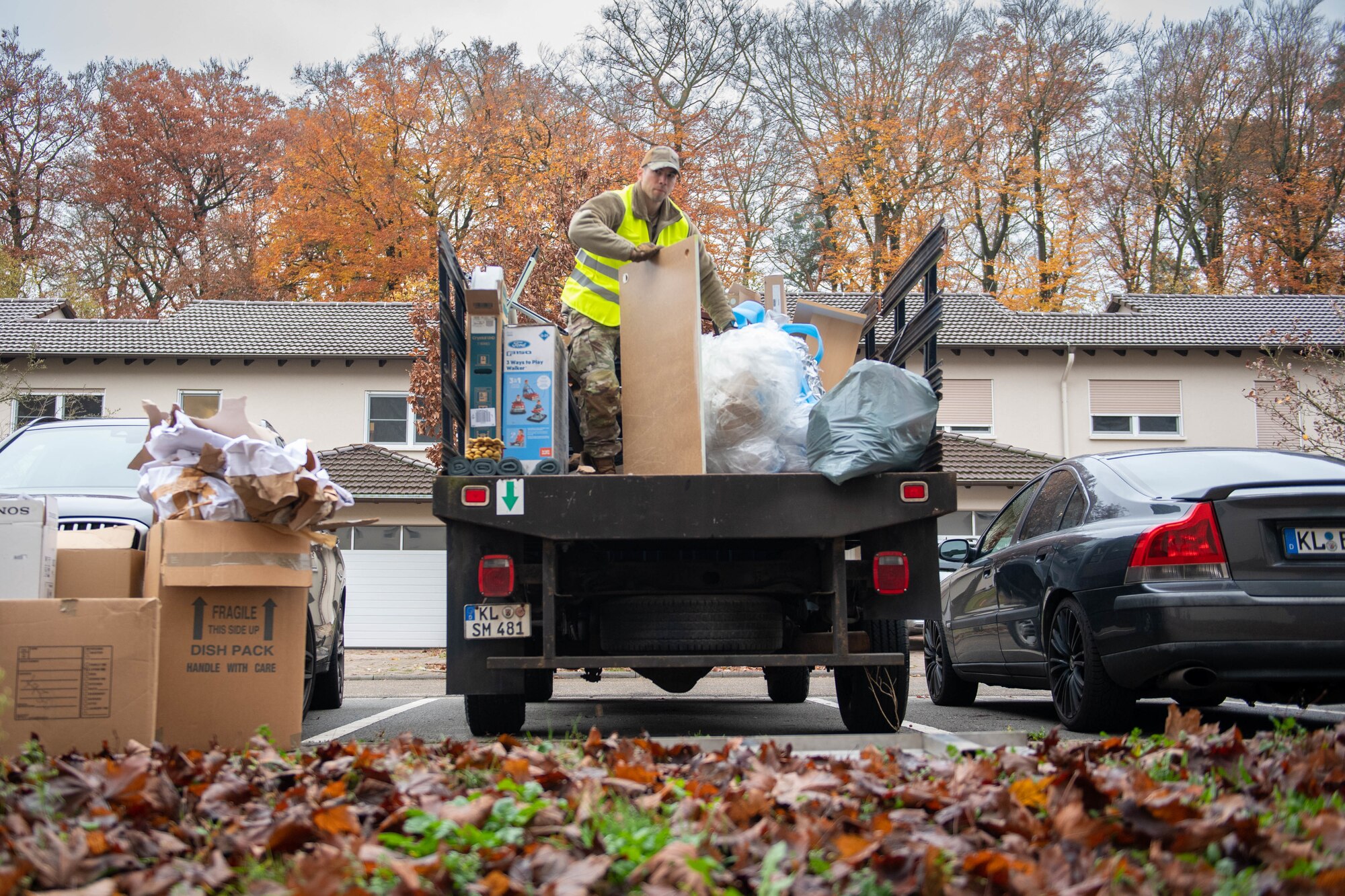 Military member fills a pickup truck with trash from base clean up.