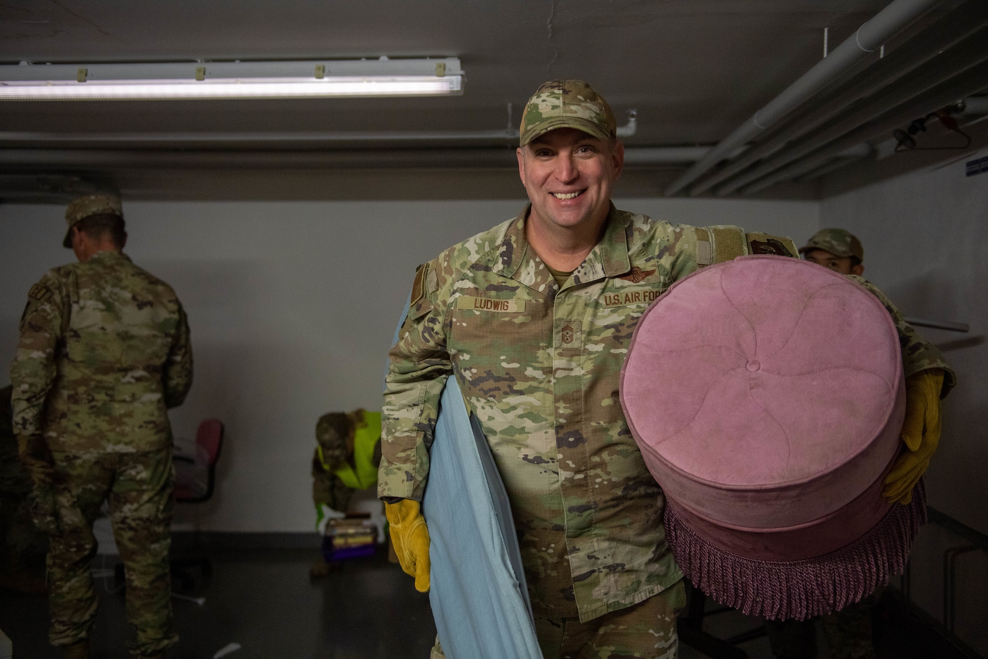 Chief Master Sgt. carries old furniture out of a basement.