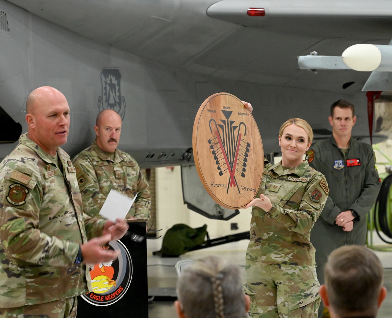 U.S. Air Force Lt. Col. Richard Schuster, 173rd Aircraft Maintenance commander, presents Klamath Tribal Council members with a memento of an aircraft nose art design at Kingsley Field in Klamath Falls, Oregon, Nov. 15, 2024. The design was created by Native artist Gwen Colman Lester and is displayed on a 173rd Fighter Wing F-15C Eagle.