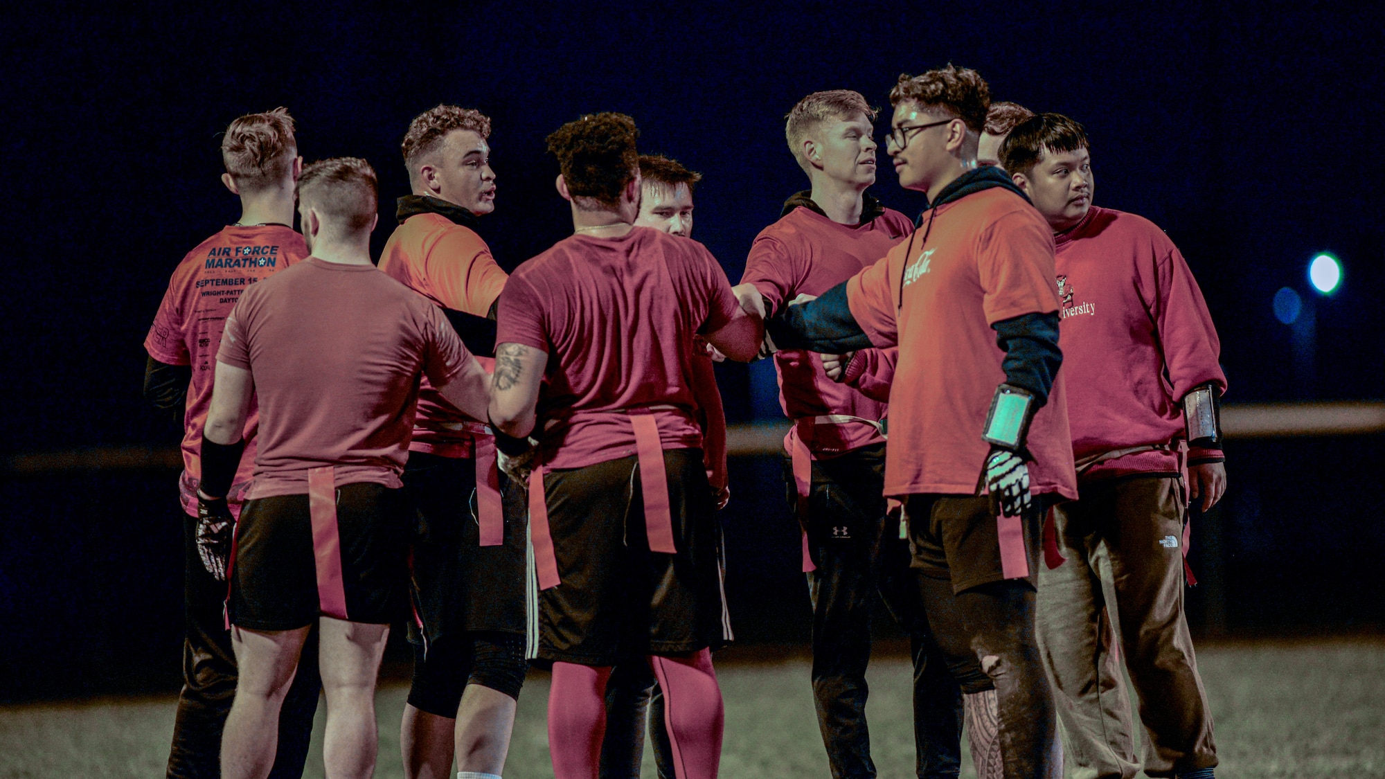 National Air and Space Intelligence Center members gather in a huddle during a flag football game.