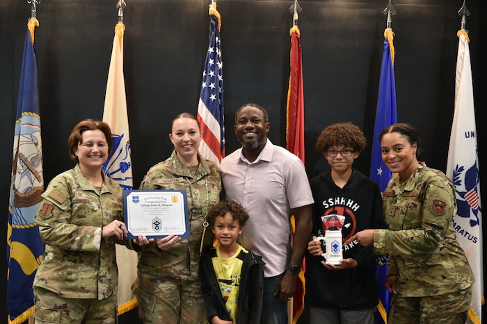 U.S. Air Force Col. Angelina Maguinness, 17th Training Wing commander, and Chief Master Sgt. Khamillia Washington, 17th TRW command chief, present a certificate of promotion and mug to Chief Master Sgt. Select Jessica Thompson, 316th Training Squadron operations superintendent, and her family during the Chief Release Party at the Powell Event Center, Goodfellow Air Force Base, Texas, Nov. 18, 2024. Thompson was one of 503 personnel selected for promotion to chief master sergeant in the 2024 promotion cycle. (U.S. Air Force photo by 1st Lt. Harris Hillstead)
