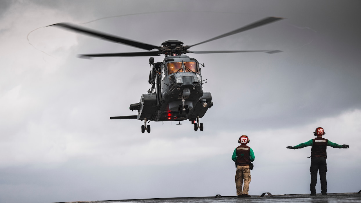 Aviation Electrician's Mate Airman Gleb Bear, from Middletown, Ohio, assigned to the Saberhawks of Helicopter Maritime Strike Squadron, signals to a Royal Canadian Air Force CH-148 Cyclone as it lands on the flight deck of Nimitz-class aircraft carrier USS George Washington (CVN 73) while underway in the Philippine Sea, Nov. 16, 2024.