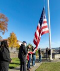 Honor guard members fold the U.S. flag Nov. 7, 2024, during a Veterans Day observance at Puget Sound Naval Shipyard & Intermediate Maintenance Facility in Bremerton, Washington. The event, hosted by the Veterans Employee Resource Group, featured a special flag-folding ceremony at the State Street Gate entrance. (U.S. Navy photo by Wendy Hallmark)