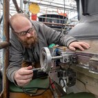 Kenyon Hall, toolmaker, Shop 31, Inside Machinists, Electroplaters and Toolmakers, demonstrates the set up and use of a new portable three-axis Logistical Escape Trunk Lug radial milling machine, Nov. 14, 2024. (U.S. Navy photo by Wendy Hallmark)
