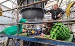 Zach Siegfried, Daniel Ryder and Roger Faber, marine machinery mechanics, Shop 38, Marine Machinst, use a new Logistical Escape Trunk Lug milling machine, Nov. 14, 2024, at Puget Sound Naval Shipyard & Intermediate Maintenance Facility in Bremerton, Washington. The machine was designed by the toolmakers in Shop 31, Inside Machinist. (U.S Navy photo by Wendy Hallmark)