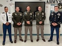 Four Male Soldiers posing in their dress uniforms.