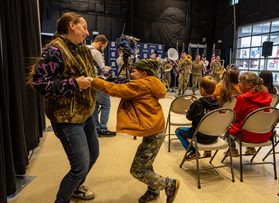 Audience members dance as a brass ensemble performs at a Naval Park.