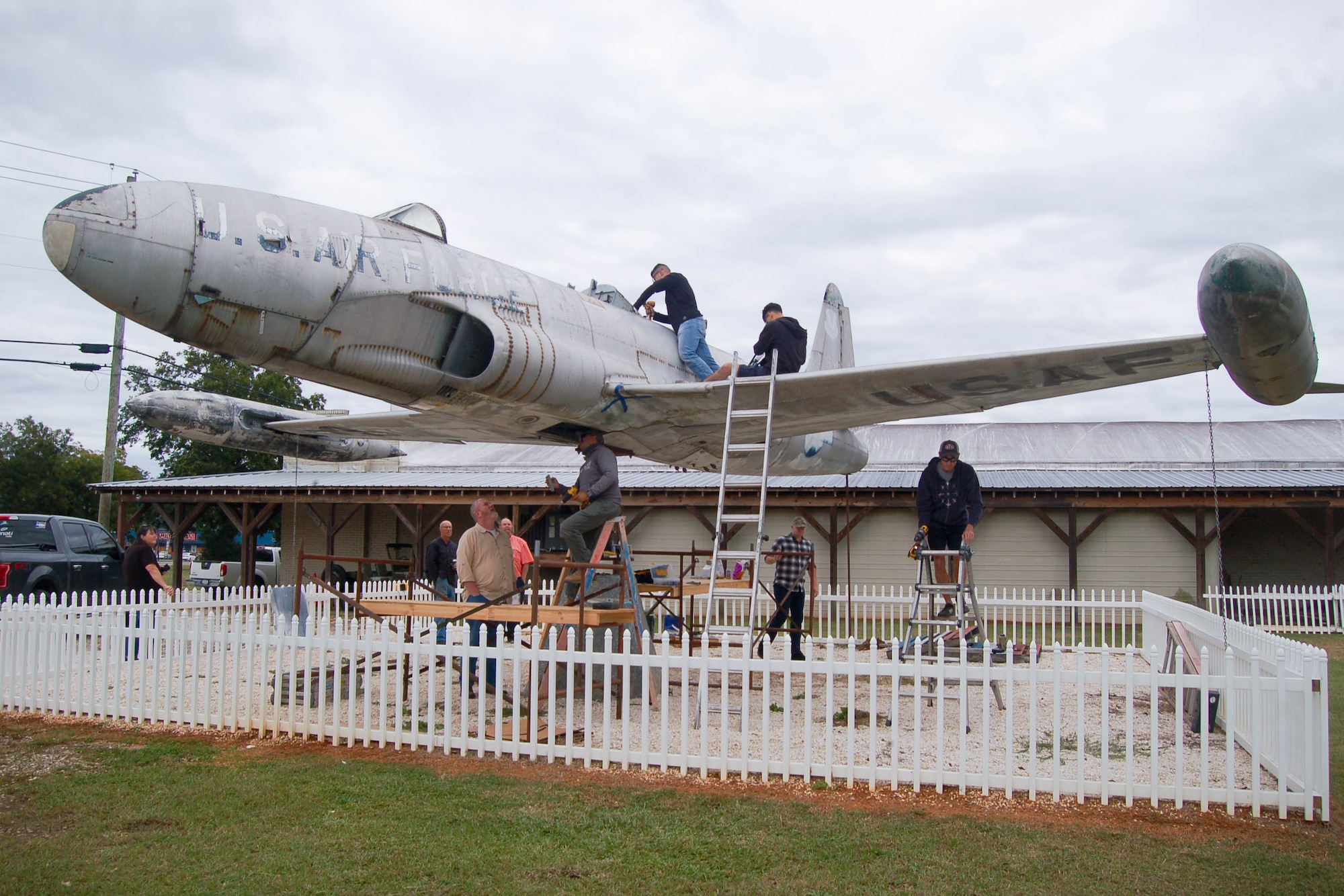 Airmen and veterans work on a T-33 Shooting Star.