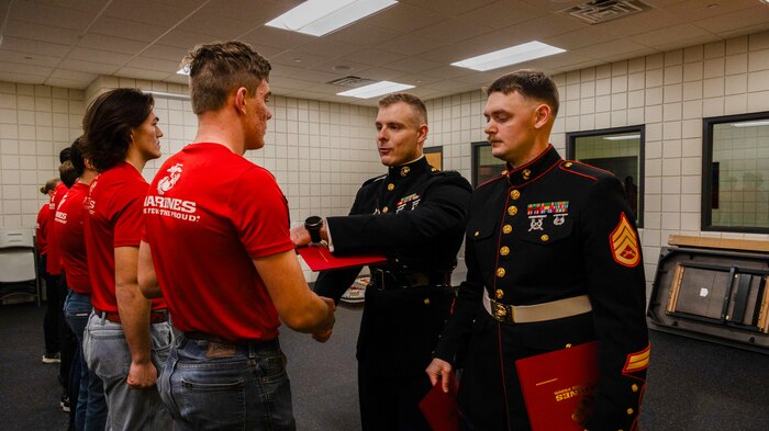 U.S. Marine Corps Capt. Jordan Olesen, an operations officer with Recruiting Station Milwaukee, congratulates the newest members of the delayed-entry-program during the monthly pool function at Dubuque, Iowa, November 16, 2024. RSS Dubuque’s pool function consisted of conducting an oath of enlistment ceremony, recognizing the newest members of the DEP, and a traditional Marine Corps cake cutting ceremony. (U.S. Marine Corps photo by Sgt. Collette Hagen)