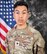 Portrait photo of U.S. Army Specialist Luciano Alcala wearing Army combat uniform in front of the U.S. flag