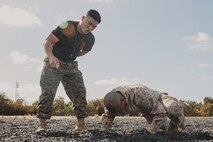 U.S. Marine Corps Martial Arts Instructor, Staff Sgt. Patrick Chok, with Support Battalion, Recruit Training Regiment, instructs a recruit with Lima Company, 3rd Recruit Training Battalion, on how to properly conduct dynamic warm-ups before a Marine Corps Martial Arts Program class at Marine Corps Recruit Depot San Diego, California, Oct. 29, 2024. MCMAP aims to strengthen the mental and moral resiliency of recruits and Marines through realistic combative training, warrior ethos studies, and physical hardening. (U.S. Marine Corps photo by Cpl. Sarah M. Grawcock)