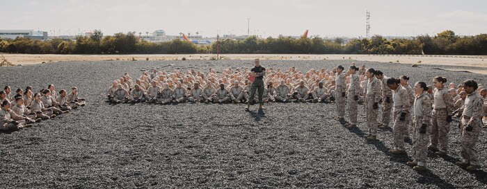 U.S. Marine Corps Martial Arts Instructor, Staff Sgt. Jacob Sinclair, with Support Battalion, Recruit Training Regiment, instructs recruits with Lima Company, 3rd Recruit Training Battalion on how to properly conduct dynamic warm-ups before a Marine Corps Martial Arts Program class at Marine Corps Recruit Depot San Diego, California, Oct. 29, 2024. MCMAP aims to strengthen the mental and moral resiliency of recruits and Marines through realistic combative training, warrior ethos studies, and physical hardening. (U.S. Marine Corps photo by Cpl. Sarah M. Grawcock)