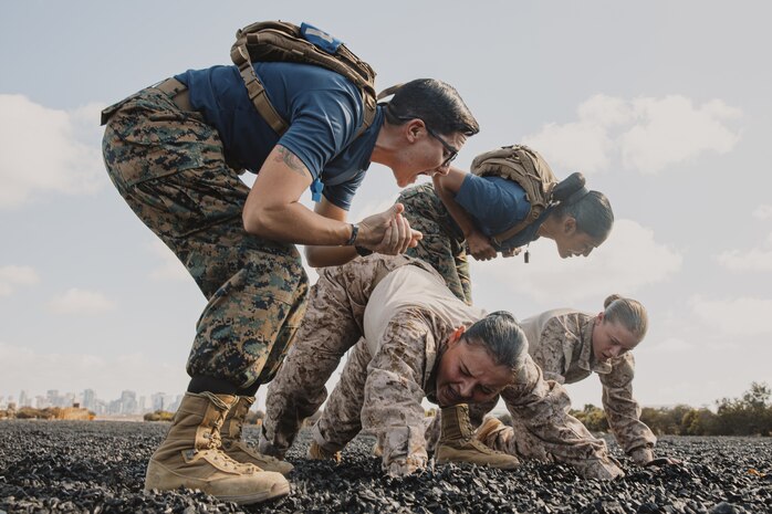 U.S. Marine Corps Sgt. Madison Polsinelli, left, and Sgt. Myrka Sorianoromero, back center, both drill instructors with Lima Company, 3rd Recruit Training Battalion, instructs recruits during dynamic warm-ups before a Marine Corps Martial Arts Program class at Marine Corps Recruit Depot San Diego, California, Oct. 29, 2024. MCMAP aims to strengthen the mental and moral resiliency of recruits and Marines through realistic combative training, warrior ethos studies, and physical hardening. (U.S. Marine Corps photo by Cpl. Sarah M. Grawcock)