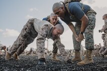 U.S. Marine Corps drill instructors with Lima Company, 3rd Recruit Training Battalion, instruct a recruit during dynamic warm-ups before a Marine Corps Martial Arts Program class at Marine Corps Recruit Depot San Diego, California, Oct. 29, 2024. MCMAP aims to strengthen the mental and moral resiliency of recruits and Marines through realistic combative training, warrior ethos studies, and physical hardening. (U.S. Marine Corps photo by Cpl. Sarah M. Grawcock)