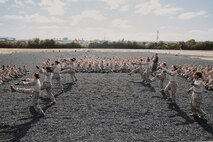 U.S. Marine Corps Martial Arts Instructor, Staff Sgt. Jacob Sinclair, with Support Battalion, Recruit Training Regiment, instructs recruits with Lima Company, 3rd Recruit Training Battalion, on how to properly conduct dynamic warm-ups before a Marine Corps Martial Arts Program class at Marine Corps Recruit Depot San Diego, California, Oct. 29, 2024. MCMAP aims to strengthen the mental and moral resiliency of recruits and Marines through realistic combative training, warrior ethos studies, and physical hardening. (U.S. Marine Corps photo by Cpl. Sarah M. Grawcock)