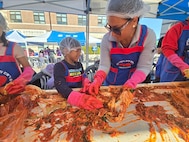 From right: Sharlene Tukumoe'atu and her son, Enoch, prepare "baechu" (cabbage) kimchi during a kimchi-making festival at Pyeongtaek University, Nov. 16, 2024.