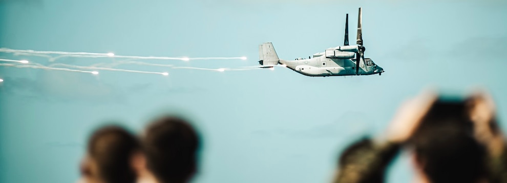 U.S. Marines assigned to the 15th Marine Expeditionary Unit, Sailors assigned to the amphibious assault ship USS Boxer (LHD 4), and embarked tigers observe an MV-22B Osprey attached to Marine Medium Tiltrotor Squadron (VMM) 165 (Reinforced), 15th MEU, dispense flares during an air power demonstration as part of a Tiger Cruise aboard Boxer in the Pacific Ocean Nov. 16, 2024.