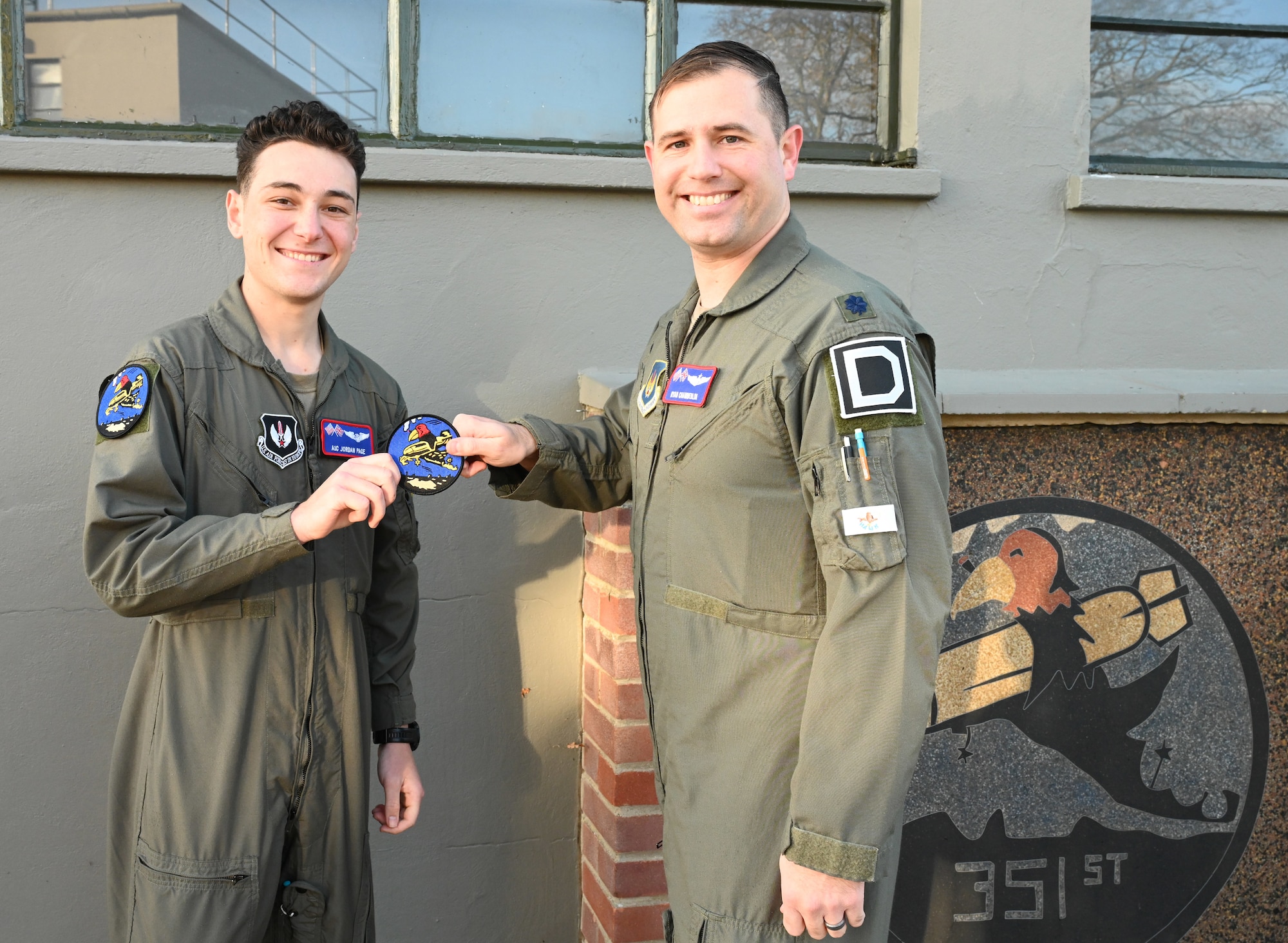 U.S. Air Force Lt. Col. Ryan Chamberlin, right, 351st Air Refueling Squadron director of operations, presents the squadron heritage “Buzzard” patch to Airman 1st Class Jordan Page, 351st ARS boom operator, during a patching ceremony at the 100th Bomb Group Memorial Museum, Thorpe Abbotts, Norfolk, England, Nov. 15, 2024. Pilots and boom operators receive their heritage patch once they complete mission-certification training. The Buzzard patch is the heritage patch of the 351st Bomb Squadron and only those who have fully completed MCT can wear the patch. (U.S. Air Force photo by Karen Abeyasekere)