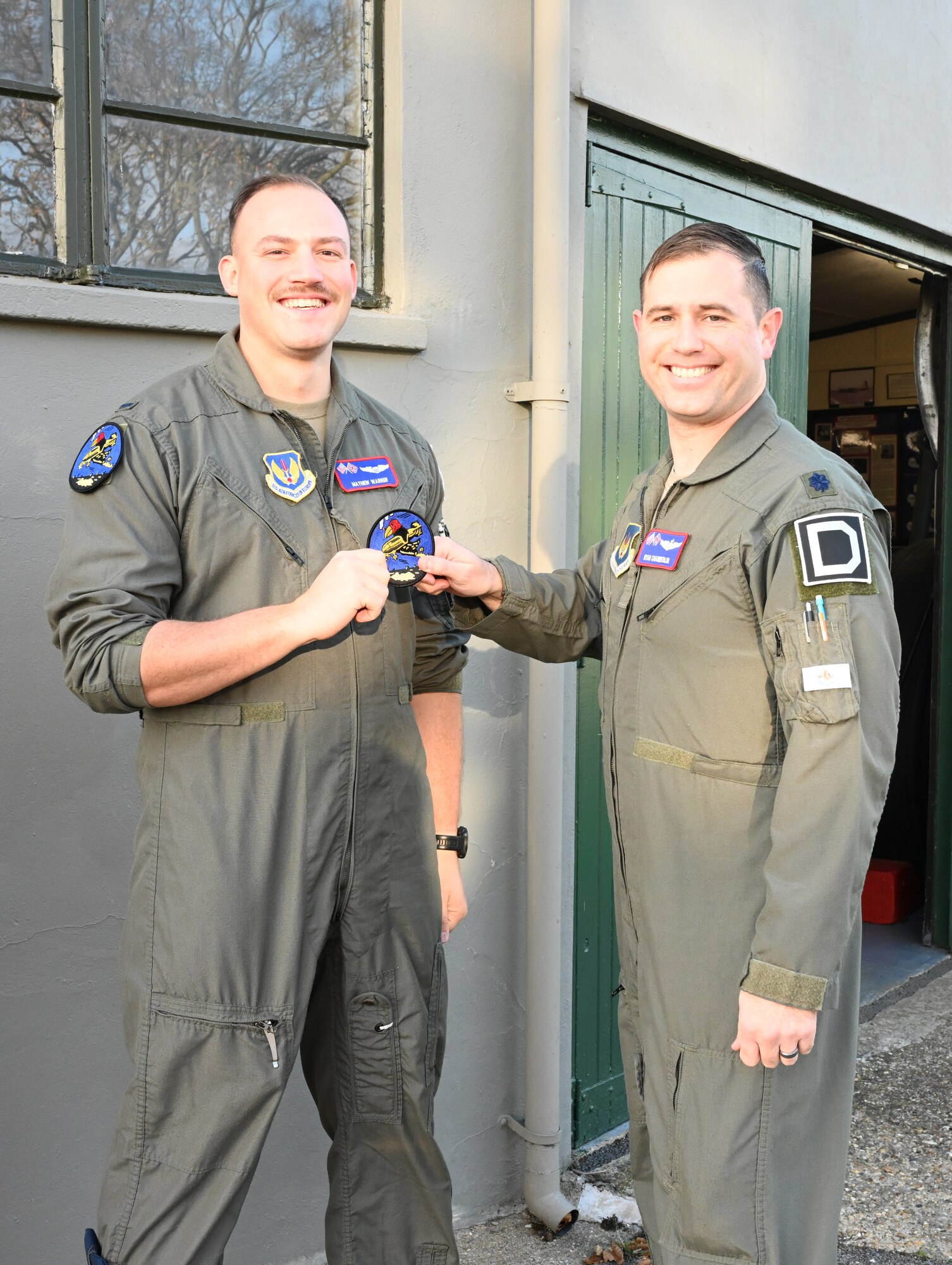U.S. Air Force Lt. Col. Ryan Chamberlin, right, 351st Air Refueling Squadron director of operations, presents the squadron heritage “Buzzard” patch to 1st Lt. Mathew Warner, 351st ARS pilot, during a patching ceremony at the 100th Bomb Group Memorial Museum, Thorpe Abbotts, Norfolk, England, Nov. 15, 2024. The Buzzard patch is the heritage patch of the 351st Bomb Squadron and only those who have fully completed mission-certification training can wear the patch. (U.S. Air Force photo by Karen Abeyasekere)
