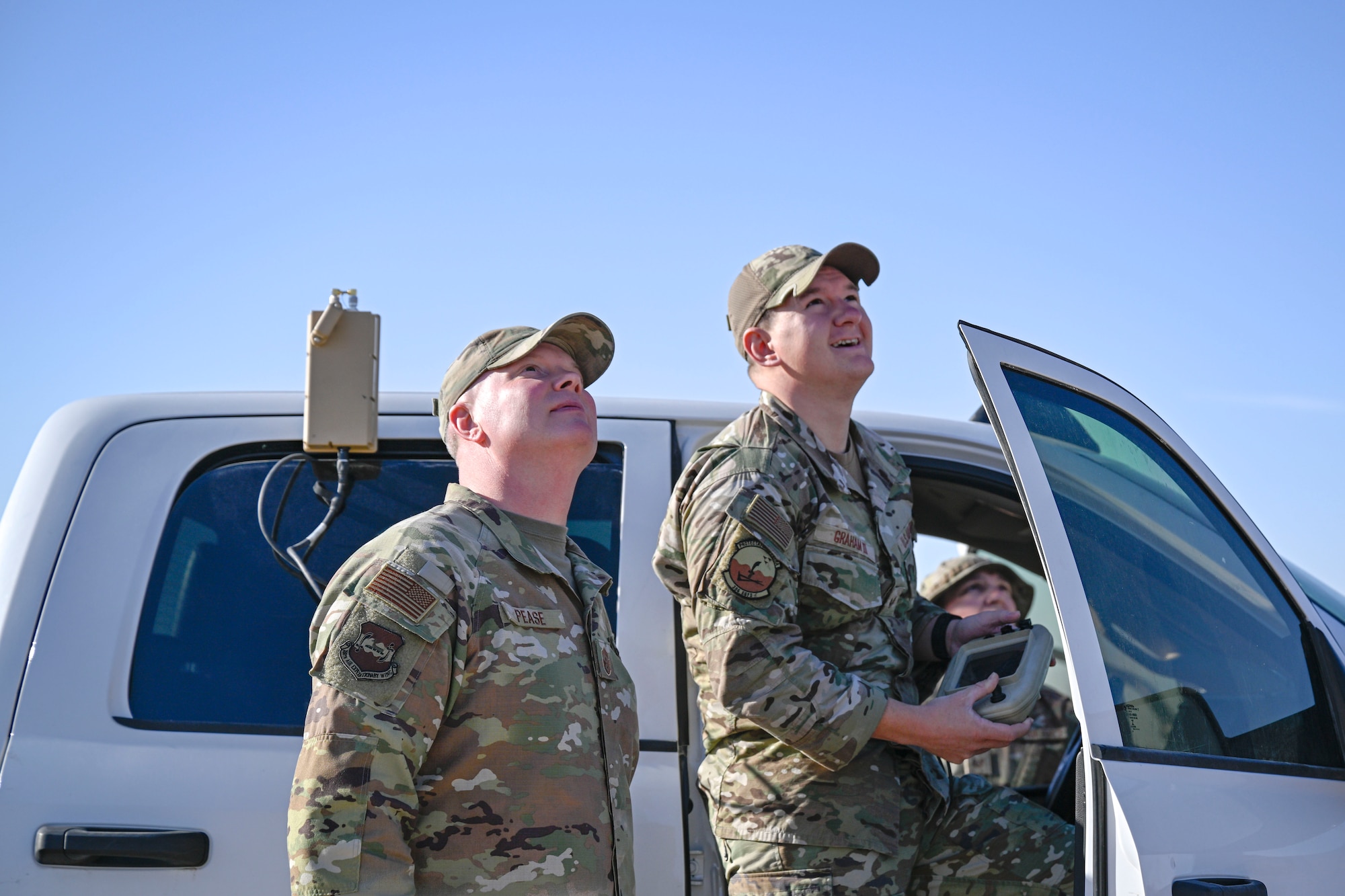 Two Airmen looking up.