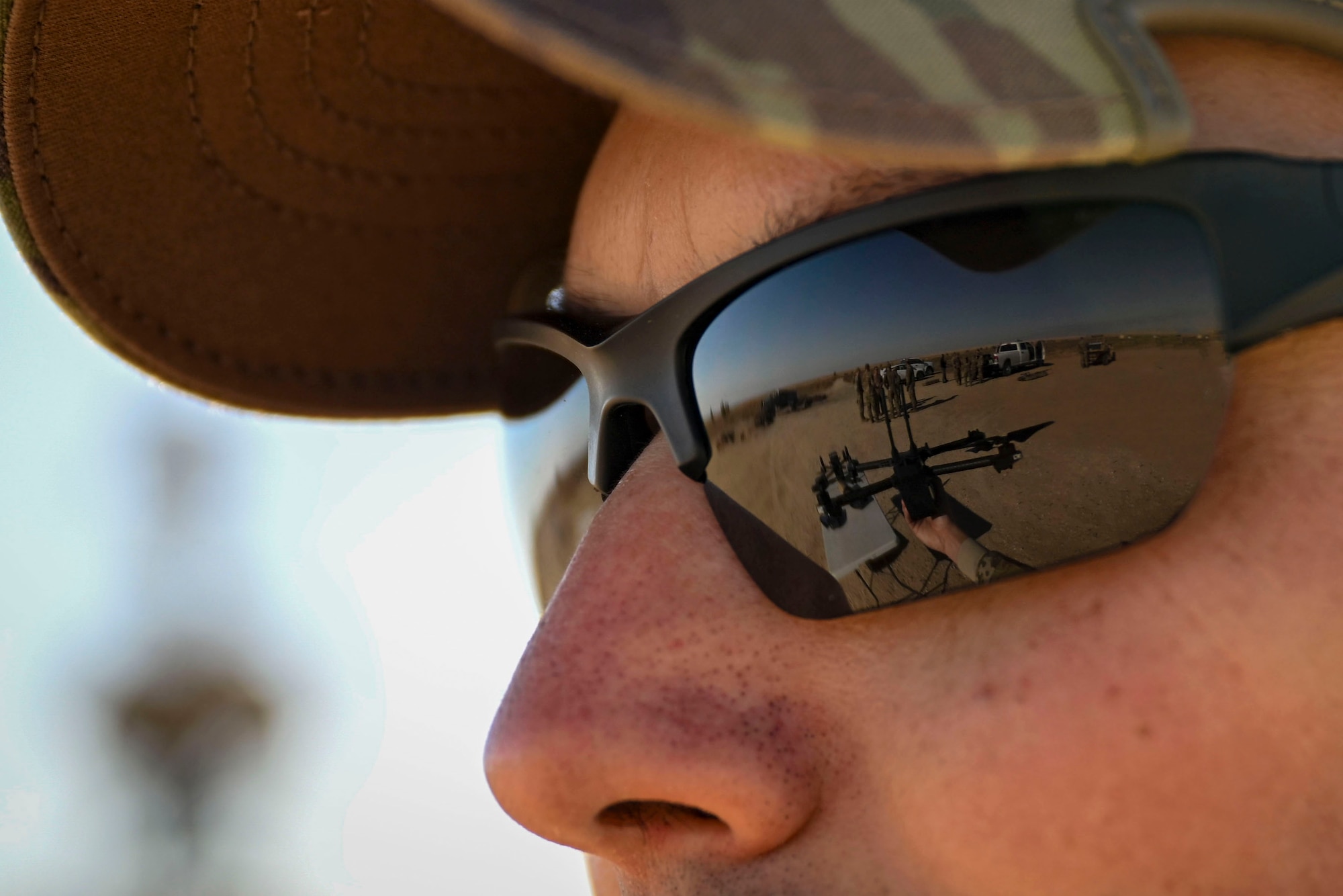The reflection of a counter-unmanned aircraft system (C-UAS) is seen in an Airman's glasses.