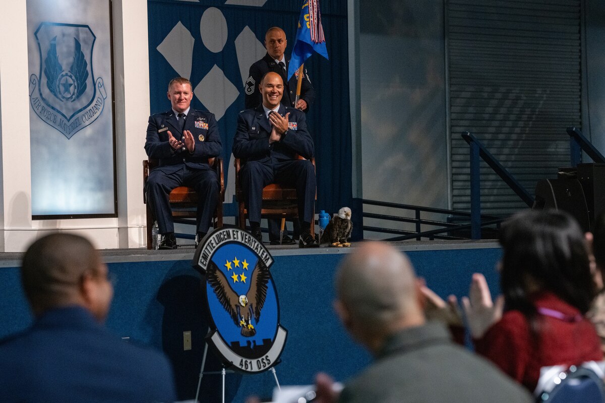 Col. Michael Lynch, 461st Operations Group commander, and Lt. Col. Richard Holt, 461st Operational Support Squadron commander, clap during the 461st OSS inactivation ceremony at Robins Air Force Base, Georgia.