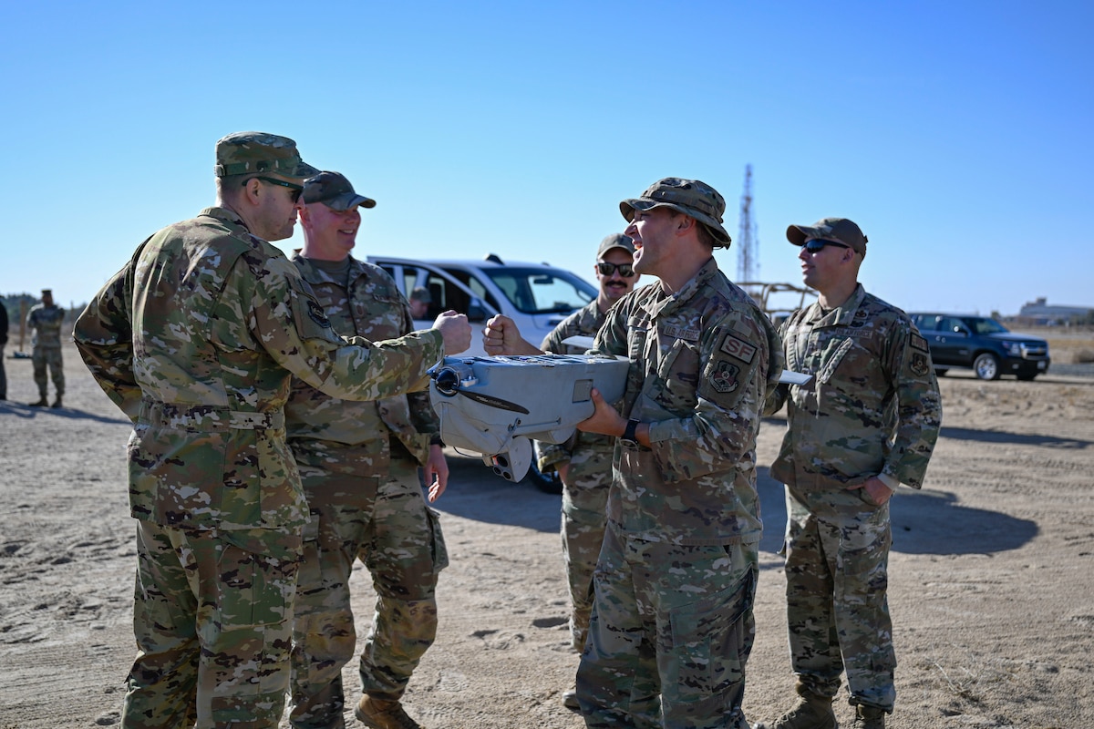 Five Airmen gather outside.