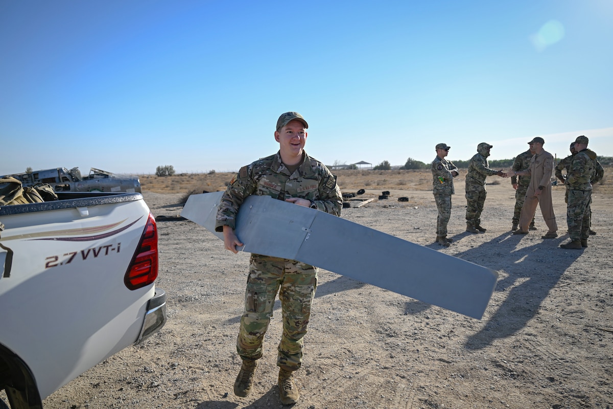 An Airman carries a small unmanned aircraft system (sUAS) wing.