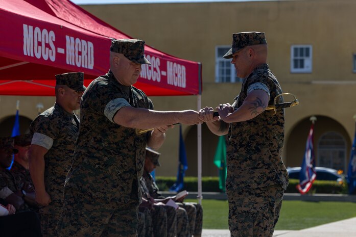 U.S. Marine Corps Col. Jason Freeby, commanding officer of Headquarters and Service Battalion, passes a sword to Sgt. Maj. Thomas Bachman, the new sergeant major of Headquarters and Service Battalion, at a relief and appointment ceremony at Marine Corps Recruit Depot San Diego, California, Oct. 31, 2024. Sgt. Maj. Carlos Aguilera relinquished his position to Bachman, who took charge of the Battalion.  (U.S. Marine Corps photo by Cpl. Alexander O. Devereux)
