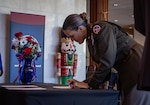 woman in military uniform signs a paper