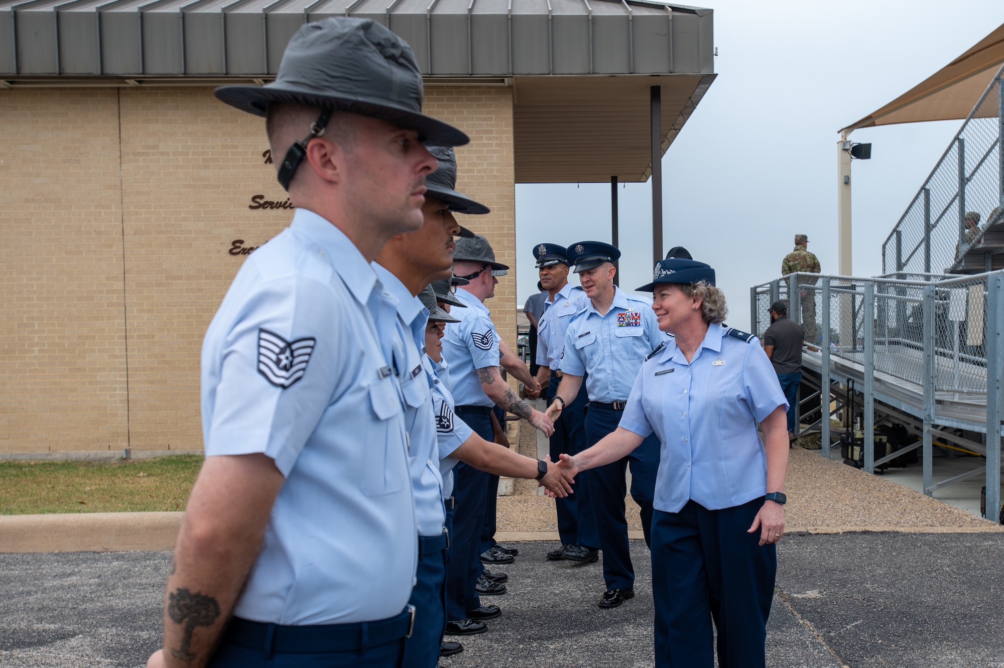 Brig. Gen. Amy Bumgarner, Air Force Office of Special Investigations commander, and Chief Master Sgt. James Hoy, AFOSI command chief, shake hands with Military Training Instructors following a Basic Military Training graduation at the parade field, Joint Base San Antonio-Lackland, Texas, Nov. 7, 2024. MTIs lined up to meet the AFOSI leaders after the ceremony, which marked a milestone for the graduating trainees. (U.S. Air Force photo by Thomas Brading)