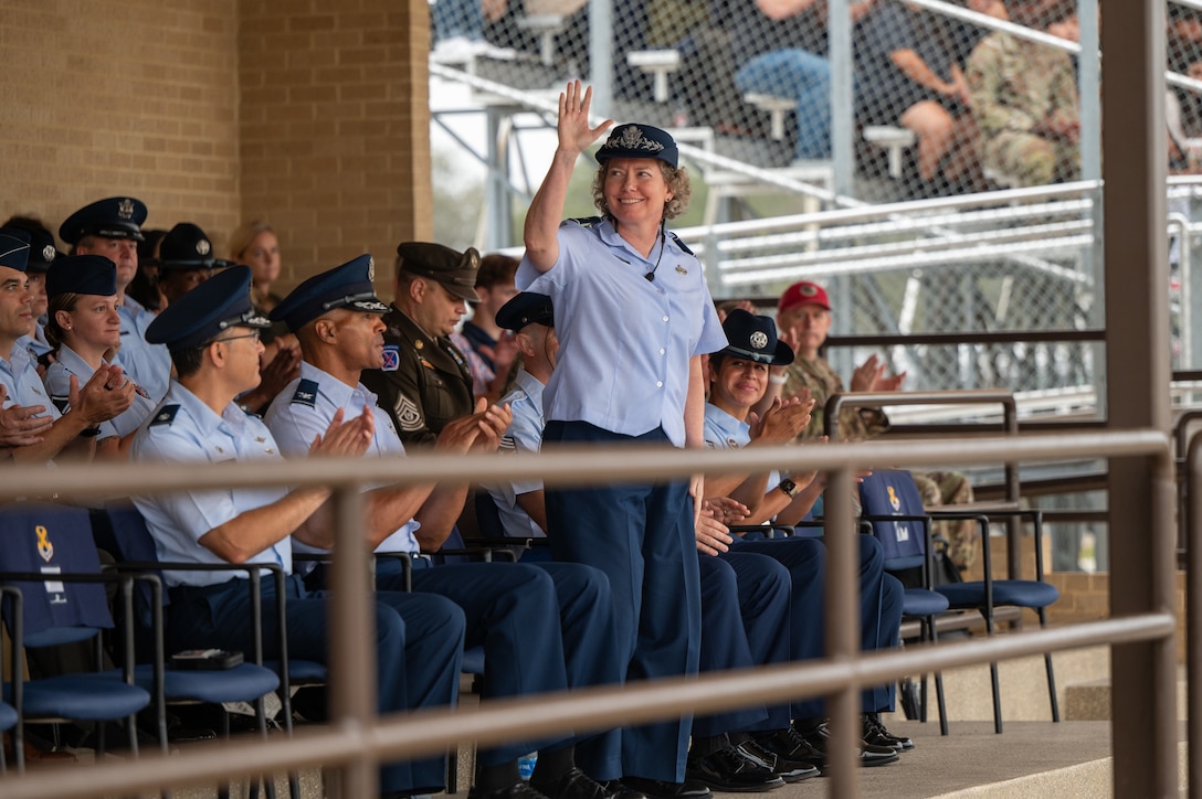 Brig. Gen. Amy Bumgarner, Air Force Office of Special Investigations commander, waves to the audience, Nov. 7, 2024, after being introduced during a Basic Military Training graduation ceremony at Joint Base San Antonio-Lackland, Texas. (U.S. Air Force photo by Thomas Brading)
