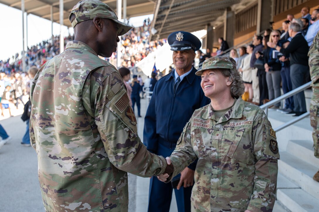 Brig. Gen. Amy Bumgarner, Air Force Office of Special Investigations commander shakes hands with Col. Willie Cooper, 37th Training Wing commander, at Basic Military Training graduation where she served as the reviewing officer at Joint Base San Antonio-Lackland, Texas, Nov. 6, 2024. (U.S. Air Force photo by Thomas Brading)