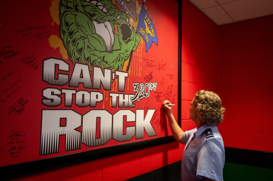 Brig. Gen. Amy Bumgarner, Air Force Office of Special Investigations commander, adds her name to a wall at the 320th Training Squadron during a basic military training dorm tour, Nov. 7, 2024, at Joint Base San Antonio-Lackland, Texas. The visit followed a graduation ceremony where she served as the guest speaker. (U.S. Air Force photo by Thomas Brading)