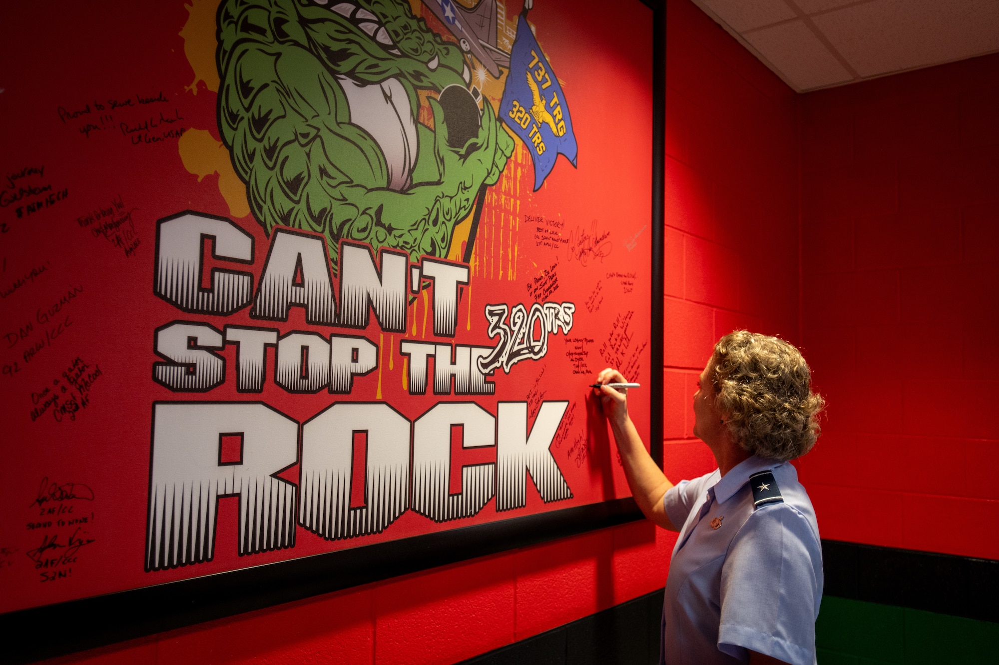 Brig. Gen. Amy Bumgarner, Air Force Office of Special Investigations commander, adds her name to a wall at the 320th Training Squadron during a basic military training dorm tour, Nov. 7, 2024, at Joint Base San Antonio-Lackland, Texas. The visit followed a graduation ceremony where she served as the guest speaker. (U.S. Air Force photo by Thomas Brading)