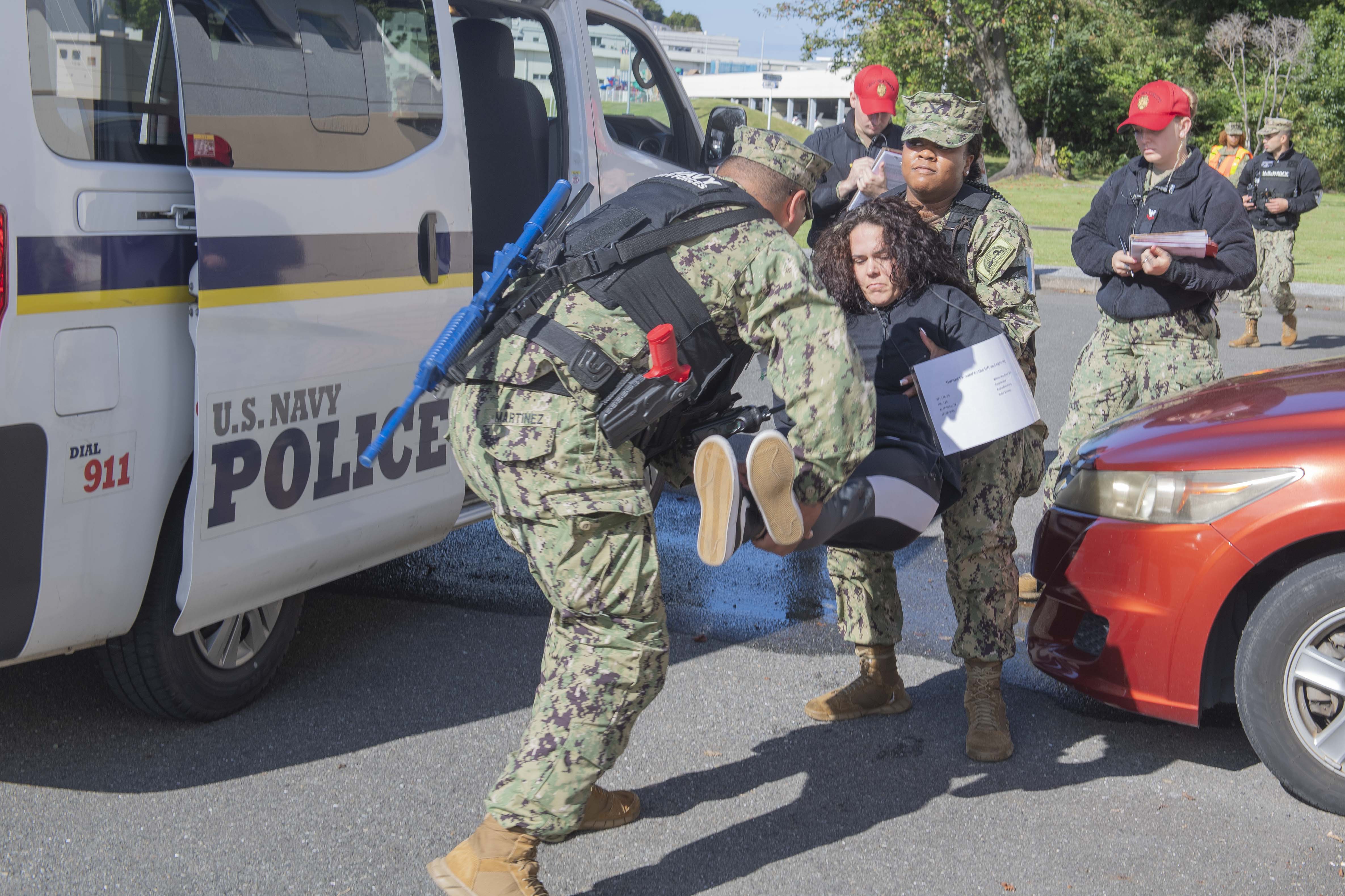 Sailors assigned to Commander, Fleet Activities Yokosuka (CFAY) pick up a simulated casualty during an active shooter drill as part of a Final Evaluation Problem (FEP) assessment at CFAY.