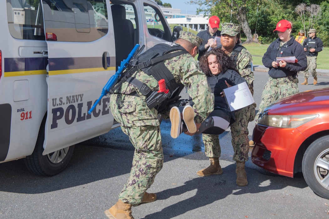 Sailors assigned to Commander, Fleet Activities Yokosuka (CFAY) pick up a simulated casualty during an active shooter drill as part of a Final Evaluation Problem (FEP) assessment at CFAY.