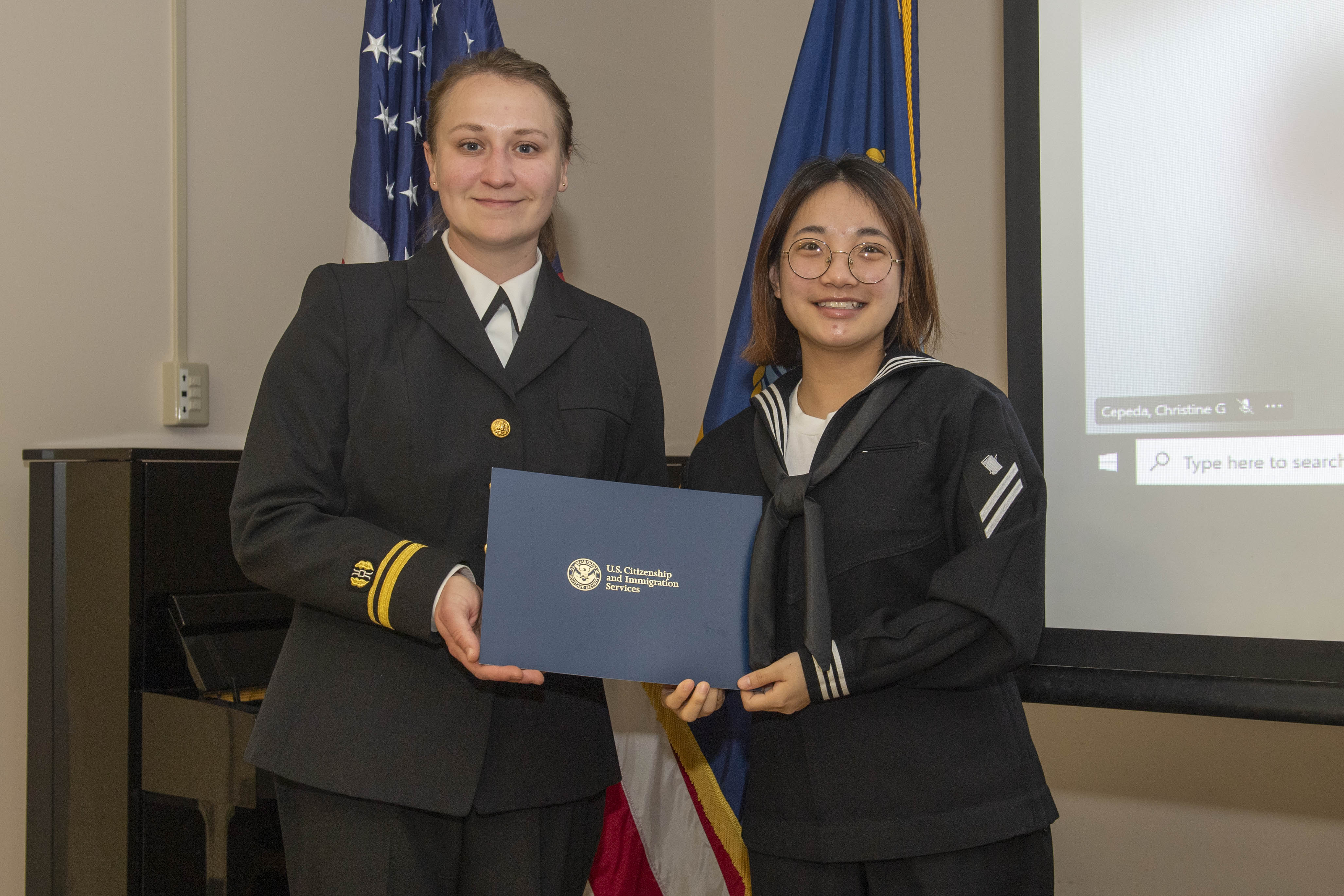 Personnel Specialist Seaman Apprentice Thu Le, assigned to Commander, Fleet Activities Yokosuka (CFAY), poses for a photo after receiving a naturalization certificate during a United States Citizenship and Immigration Services naturalization ceremony hosted by Region Legal Service Office Western Pacific, at CFAY’s Community Readiness Center.