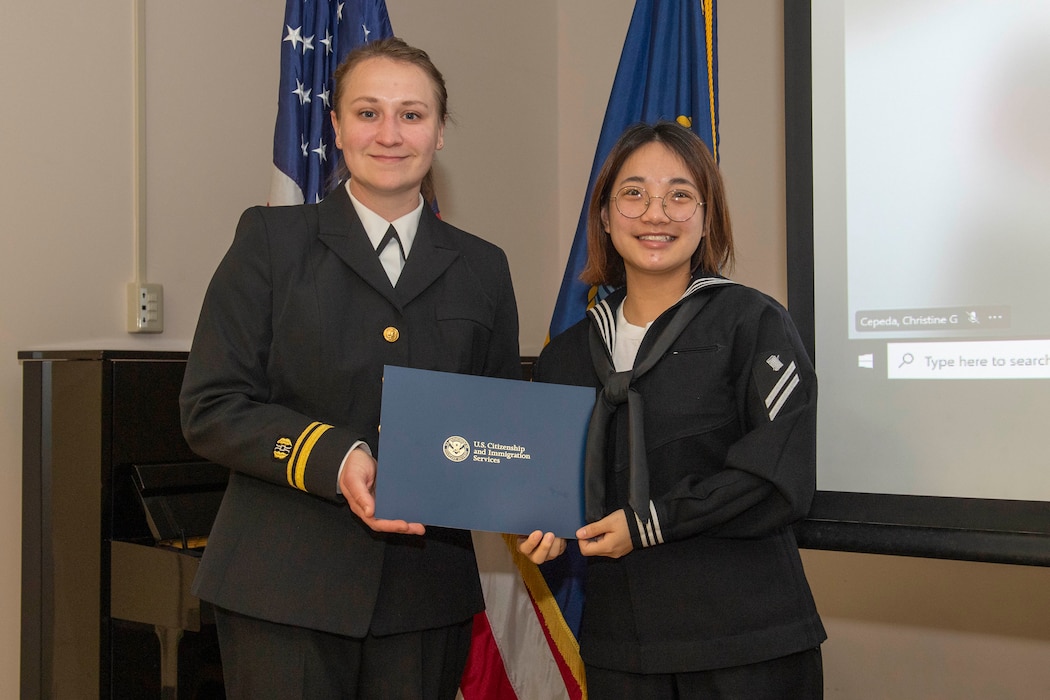 Personnel Specialist Seaman Apprentice Thu Le, assigned to Commander, Fleet Activities Yokosuka (CFAY), poses for a photo after receiving a naturalization certificate during a United States Citizenship and Immigration Services naturalization ceremony hosted by Region Legal Service Office Western Pacific, at CFAY’s Community Readiness Center.