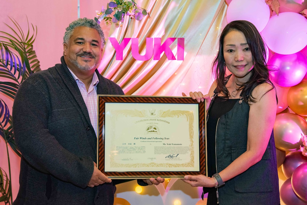 Administrative Specialist Yuki Yamamoto, with Fleet Readiness onboard Commander, Fleet Activities Yokosuka (CFAY) receives a Certificate of Farewell and Appreciation, and poses with Esteban Abreu, CFAY installation housing program director, during her farewell party.