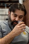 U.S. Air Force Master Sgt. Matthew Elder, Special Warfare Training Wing readiness flight chief, checks a sample from barrels in a distillery rack house as part of his SkillBridge internship at a local distillery, San Antonio, Texas, May 10, 2024. The DOD SkillBridge Program allows separating service members to intern with approved industry partners for up to 180 days prior to their separation date as long as the obtain their chain of command approval. The program is designed to give service members valuable industry experience and help smooth the transition between military and civilian life. Elder used his SkillBridge benefit to explore career opportunities in the distilling and beverage industry. (U.S. Air Force photo by Ismael Ortega)