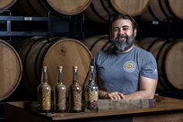 U.S. Air Force Master Sgt. Matthew Elder, Special Warfare Training Wing readiness flight chief, poses for a photo at a distillery where he is performing his SkillBridge internship in San Antonio, Texas, May 10, 2024. The DOD SkillBridge Program allows separating service members to intern with approved industry partners for up to 180 days prior to their separation date as long as the obtain their chain of command approval. The program is designed to give service members valuable industry experience and help smooth the transition between military and civilian life. Elder used his SkillBridge benefit to explore career opportunities in the distilling and beverage industry. (U.S. Air Force photo by Ismael Ortega)